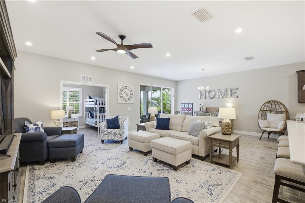 Bright living area featuring recessed lighting, a ceiling fan, and light-toned walls