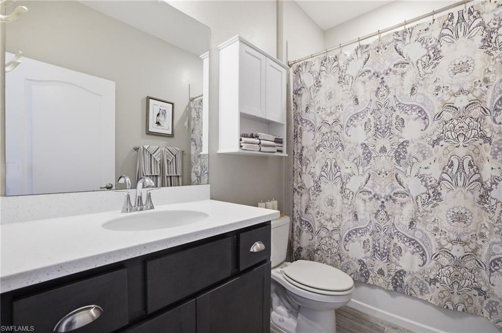 Bathroom featuring a dark wood-finish vanity with a white countertop and undermount sink