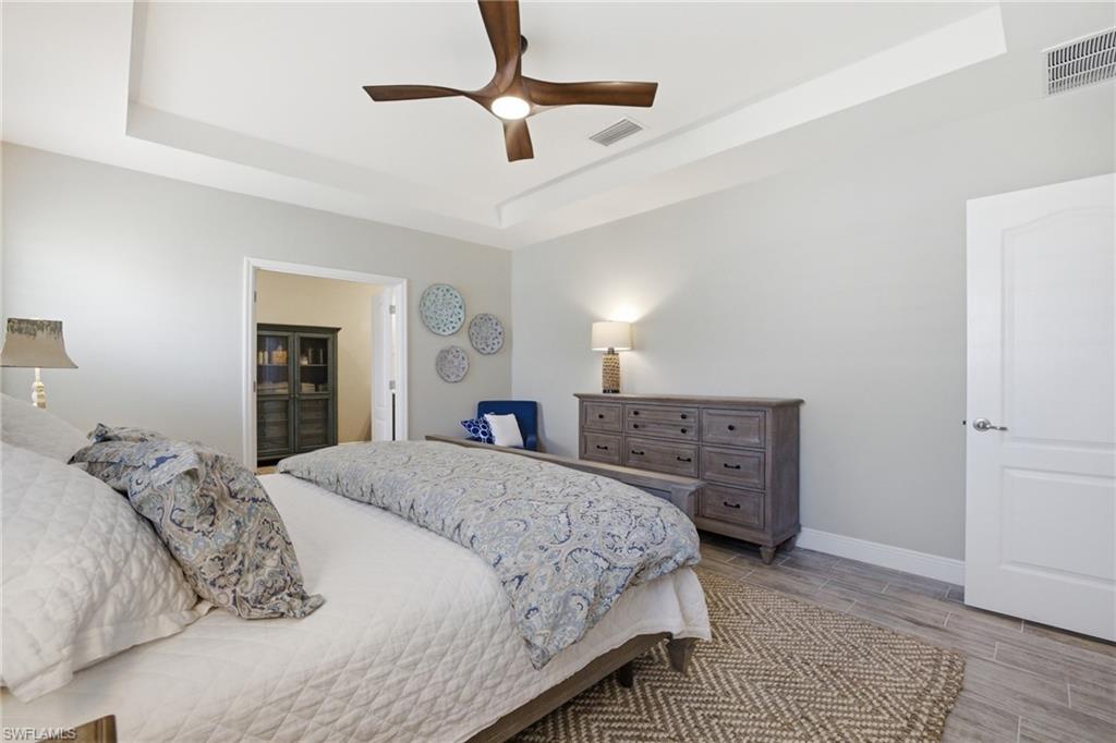 Tray ceiling with a contemporary ceiling fan and recessed lighting