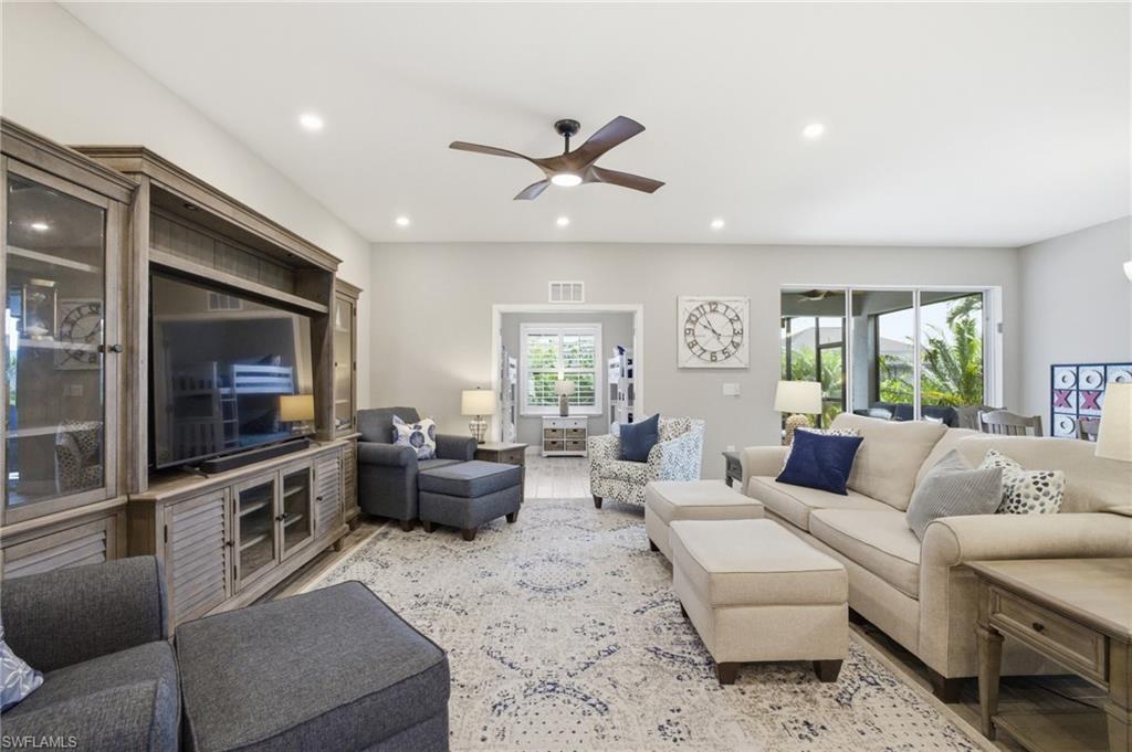 Spacious living area featuring light-toned walls and wood-finish flooring