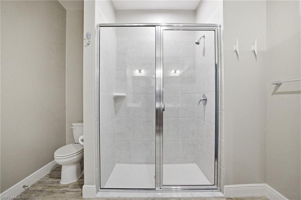 Walk-in shower with clear glass enclosure and brushed chrome fixtures