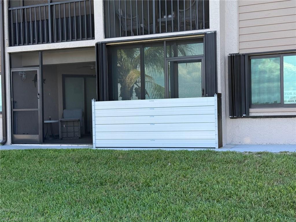 Ground-level patio with a screen door entry and an adjacent window with exterior shutters