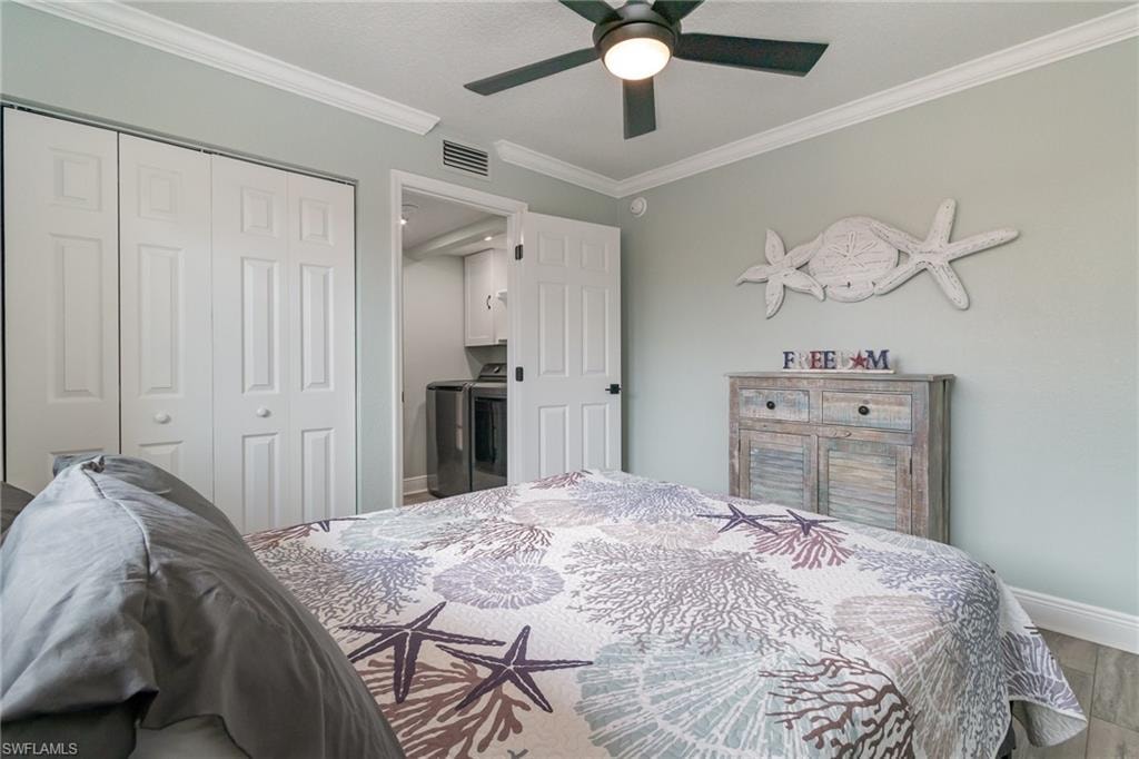 Bedroom featuring ornamental molding, baseboards, visible vents, a closet, and wood finished floors