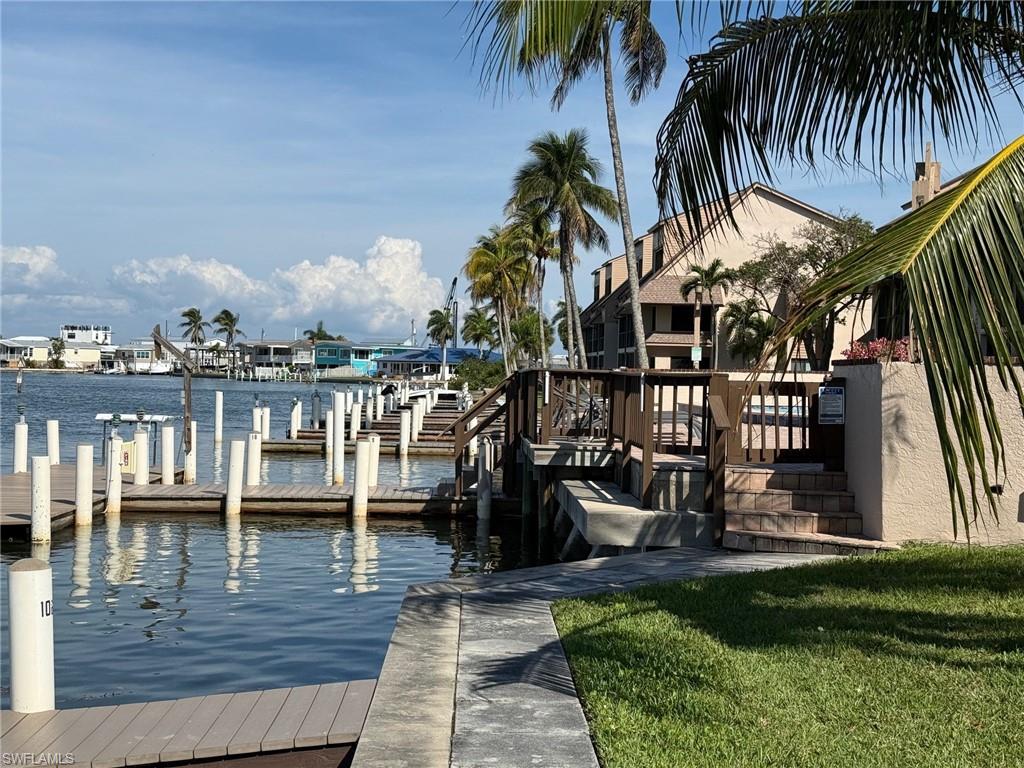 Waterfront property featuring multiple boat slips, composite decking, and a concrete walkway