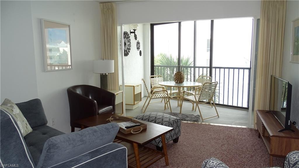 Living area featuring light-colored walls and a screened balcony
