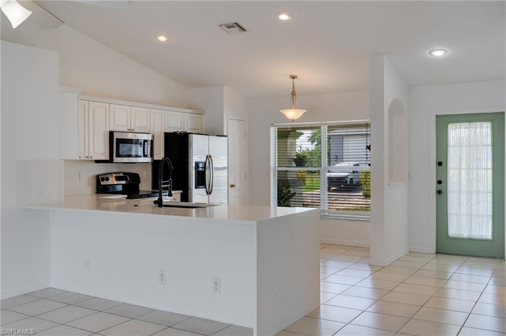 Kitchen featuring a peninsula with a white countertop, white cabinetry, and stainless-steel appliances