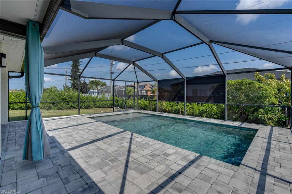 Screened outdoor space featuring a rectangular swimming pool with integrated spa