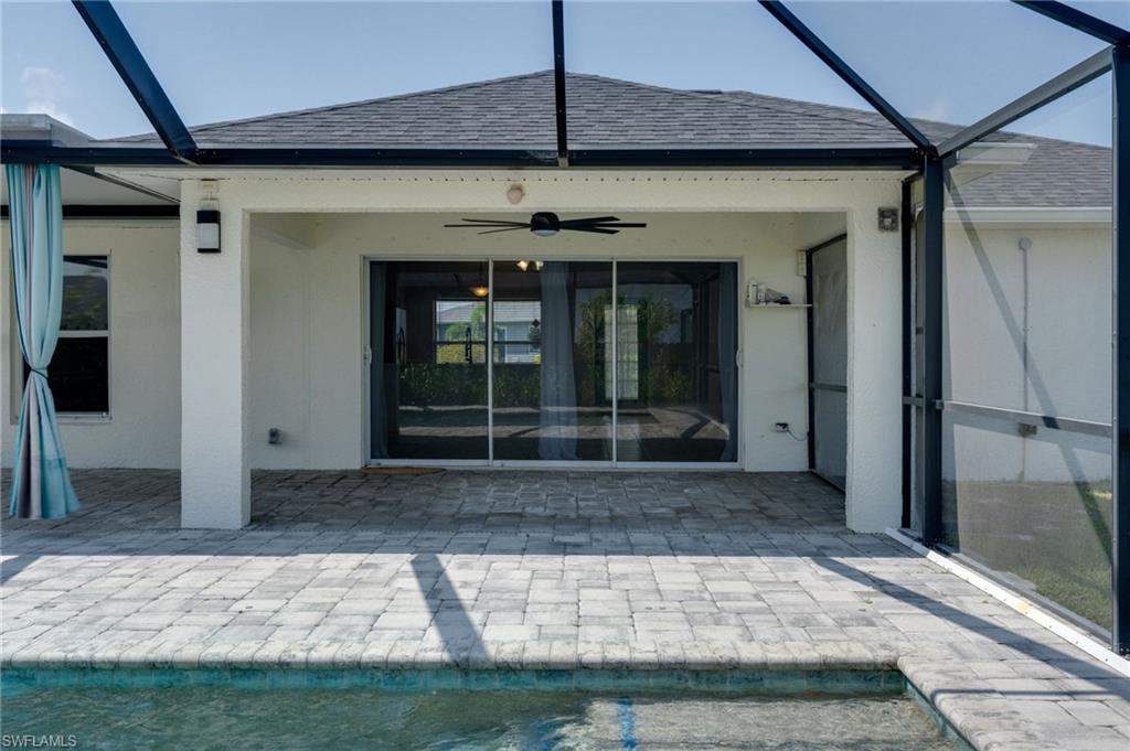 Screened-in lanai featuring a covered patio with paver flooring