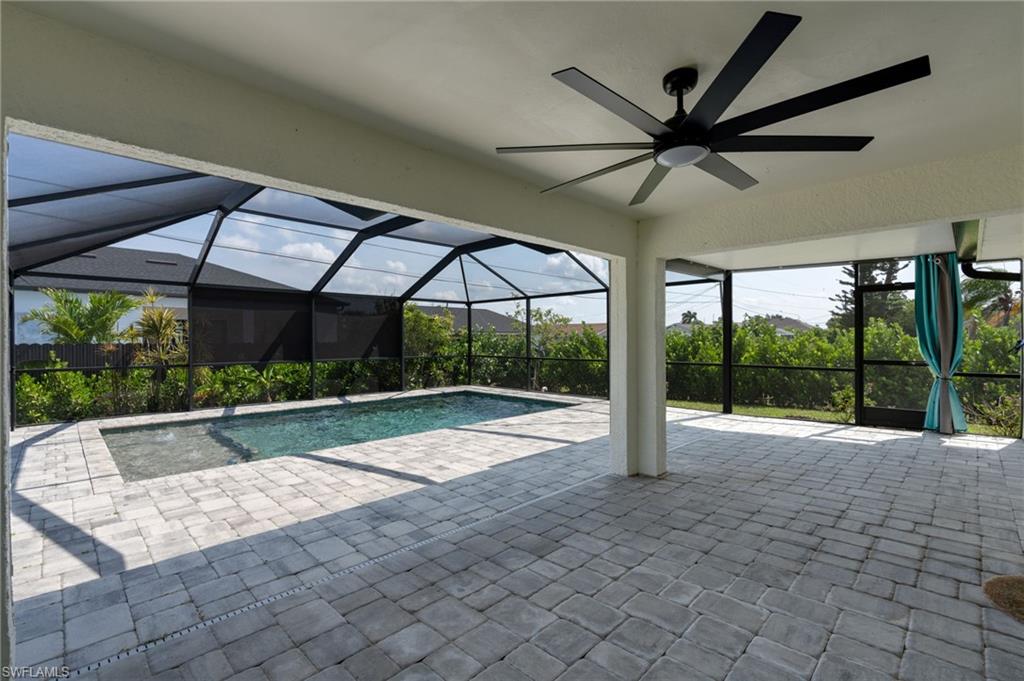 Expansive screened lanai featuring a swimming pool, integrated spa, and light-toned paver flooring