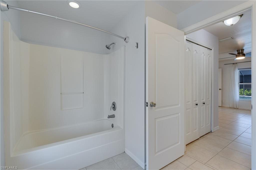 Tub and shower combination with a single-handle faucet and integrated shelving