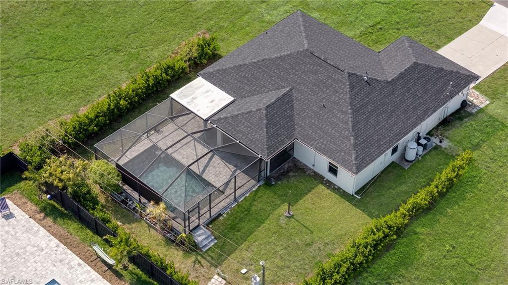 Aerial perspective showcasing a single-story residence with a dark shingle roof