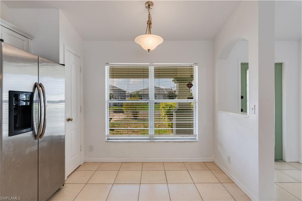 Open concept dining area with tiled flooring and a brushed nickel ceiling fixture
