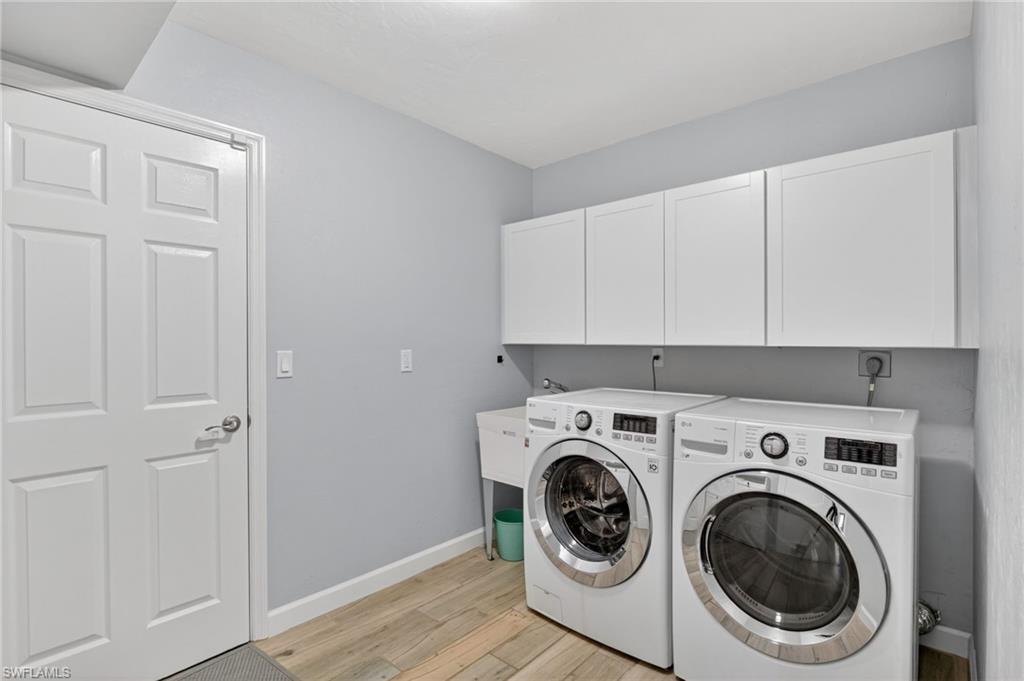 Dedicated laundry area featuring wood-finish flooring