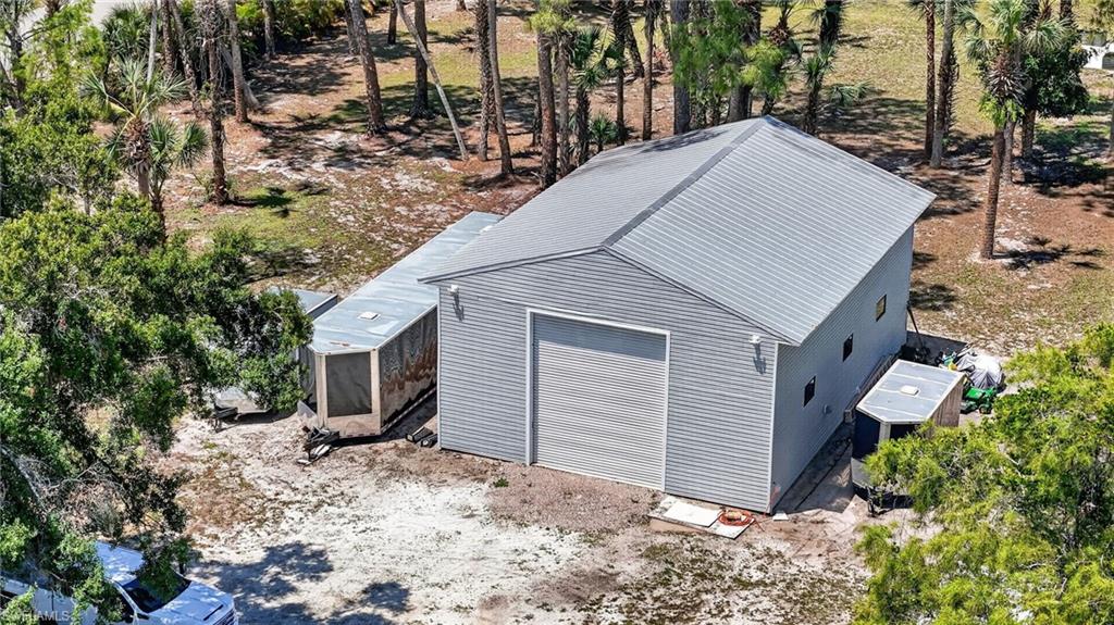Freestanding structure with light gray horizontal siding and a matching metal roof