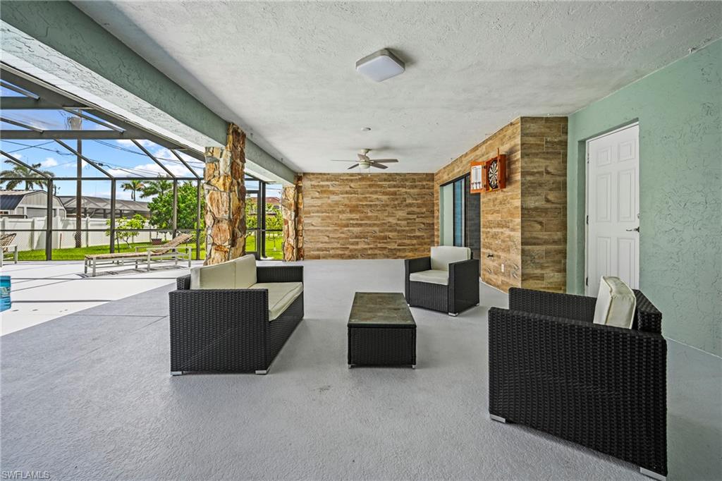 Expansive screened patio featuring stone accent walls, a ceiling fan, and recessed lighting