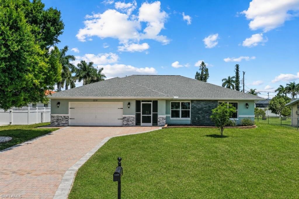 Single-story residence featuring a gray shingle roof, light blue exterior siding, and decorative stone accents