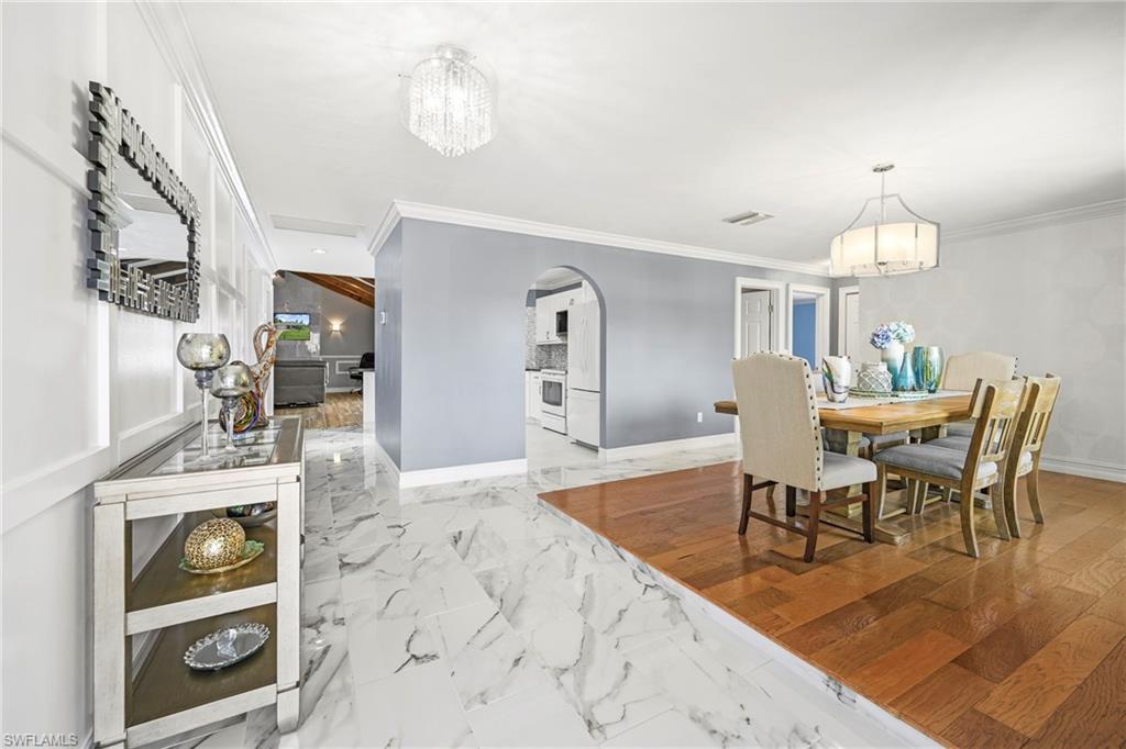 Bright interior featuring a formal dining area with wood-finish flooring and a decorative chandelier