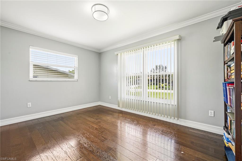 Bright interior space featuring wood-finish flooring, light gray walls, and white crown molding