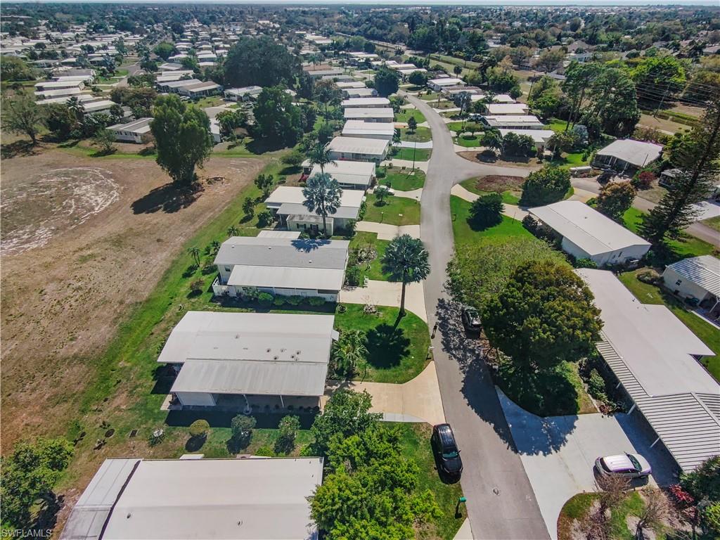 Aerial view showcasing a residential community with paved roadways and mature landscaping