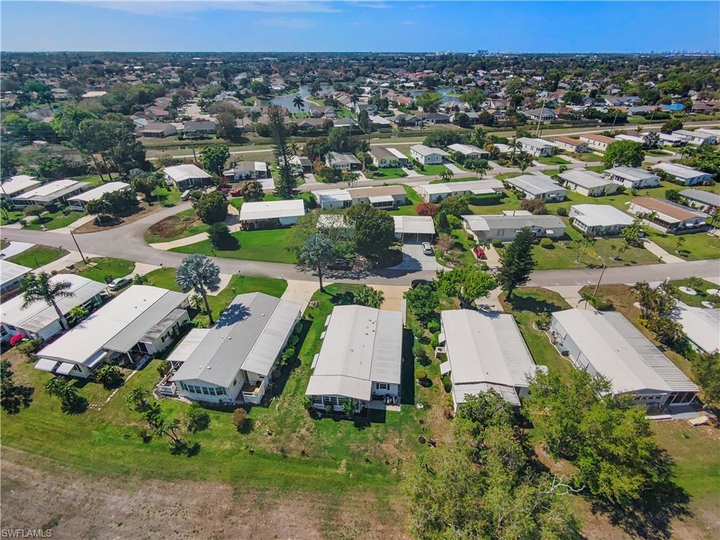 Aerial perspective showcasing a residential community with numerous single-story homes and mature trees