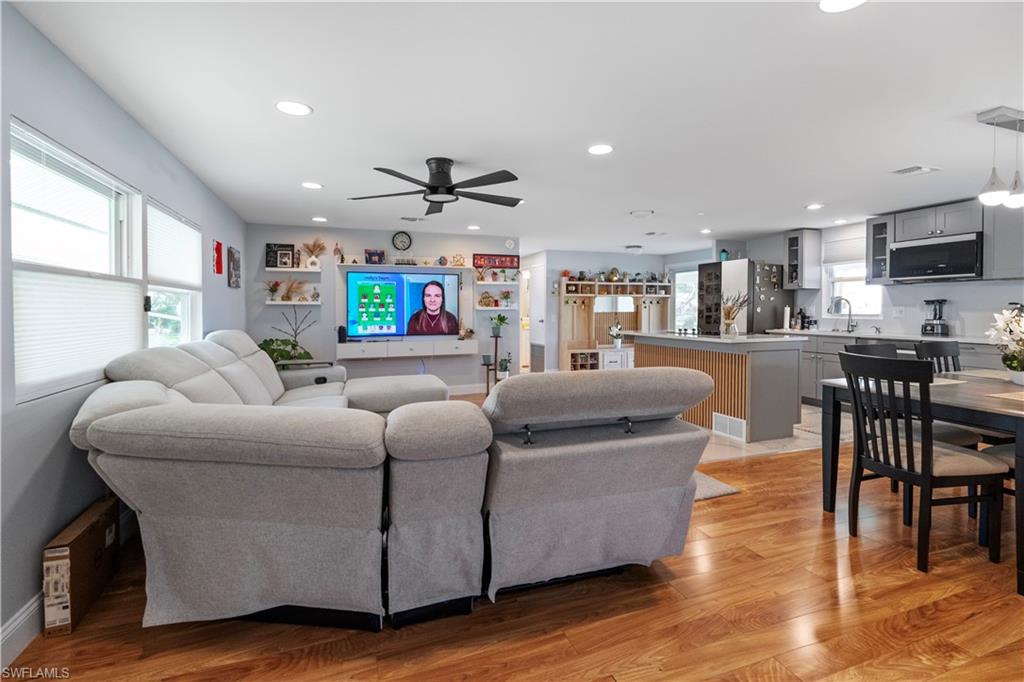 Open-concept living space featuring wood-finish flooring, recessed lighting, and a ceiling fan