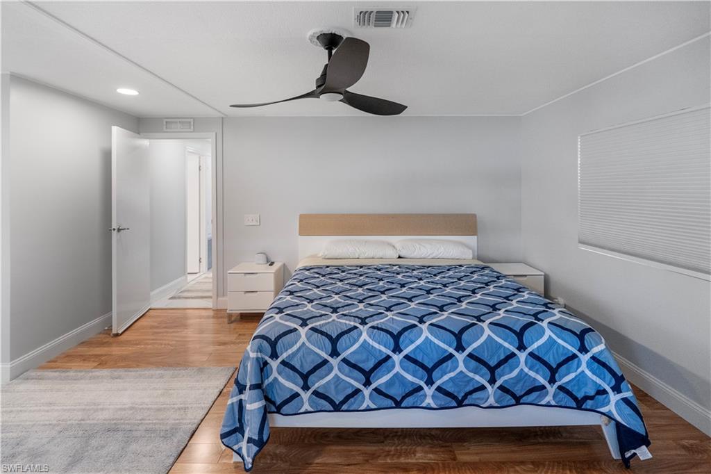 Bedroom featuring wood-finish flooring, a contemporary ceiling fan, recessed lighting, and a window with cellular shades