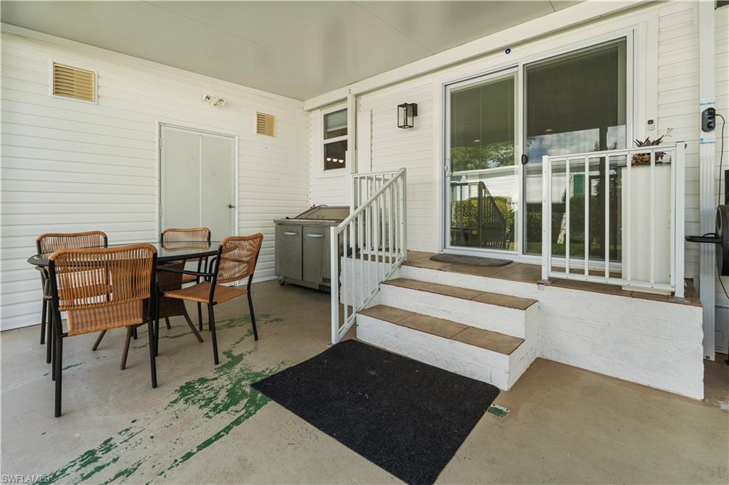 Covered outdoor patio with a concrete surface, white siding, and a built-in outdoor lighting fixture