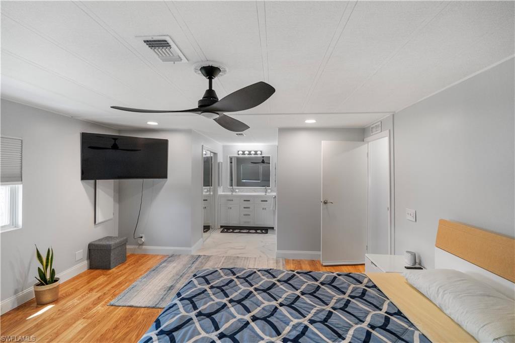 Hardwood-style flooring in this room featuring a ceiling fan with integrated lighting, recessed lighting, and white baseboards
