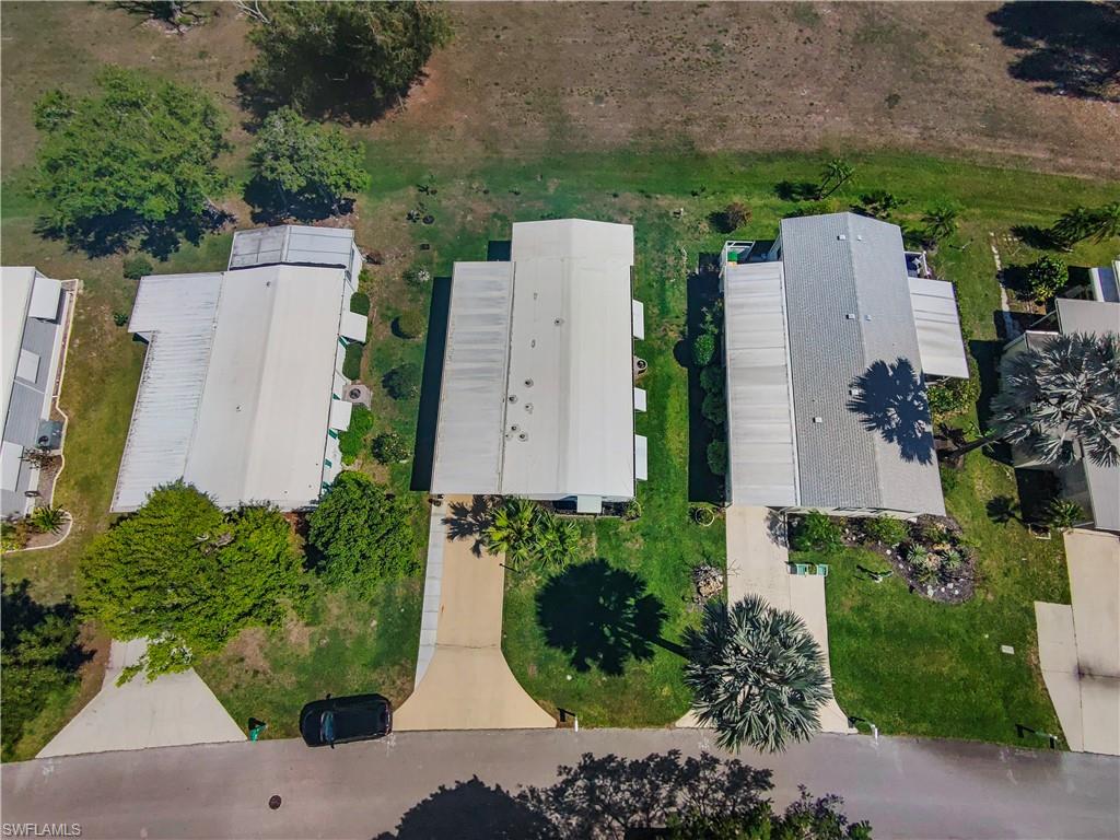 Aerial perspective showcasing three properties with expansive green space