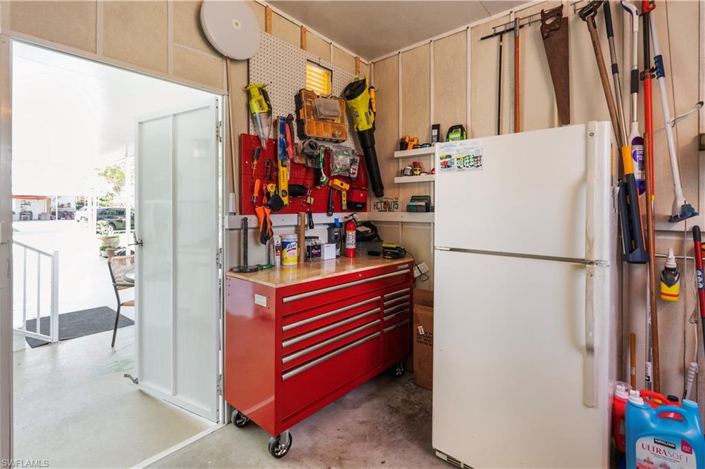Utility space featuring a workbench with wood-finish top and red storage drawers
