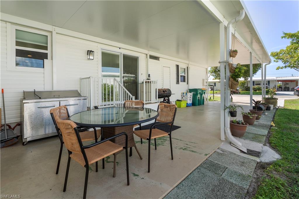 Expansive covered patio featuring a concrete surface, white siding, and a stainless-steel outdoor storage unit