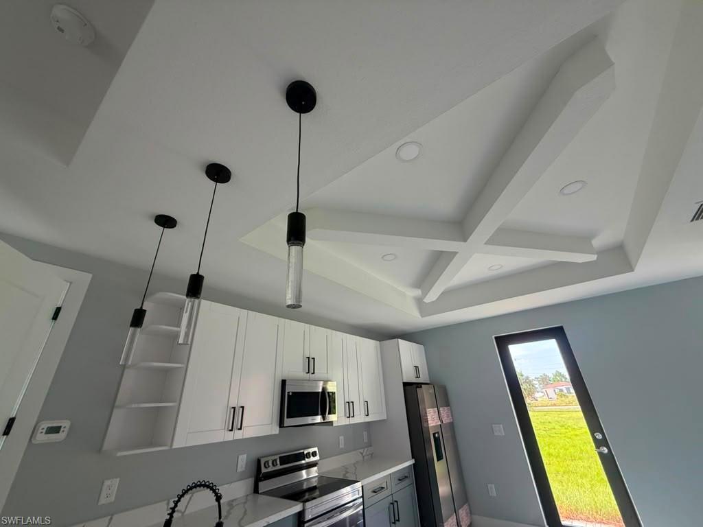 Open-concept living space featuring large-format tile flooring, a decorative wall panel with an integrated linear electric fireplace, and a tray ceiling with recessed lighting