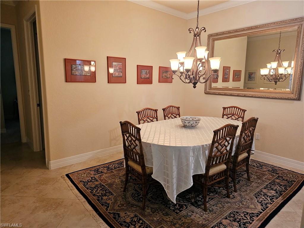 Dining area with a chandelier, ornamental molding, and baseboards