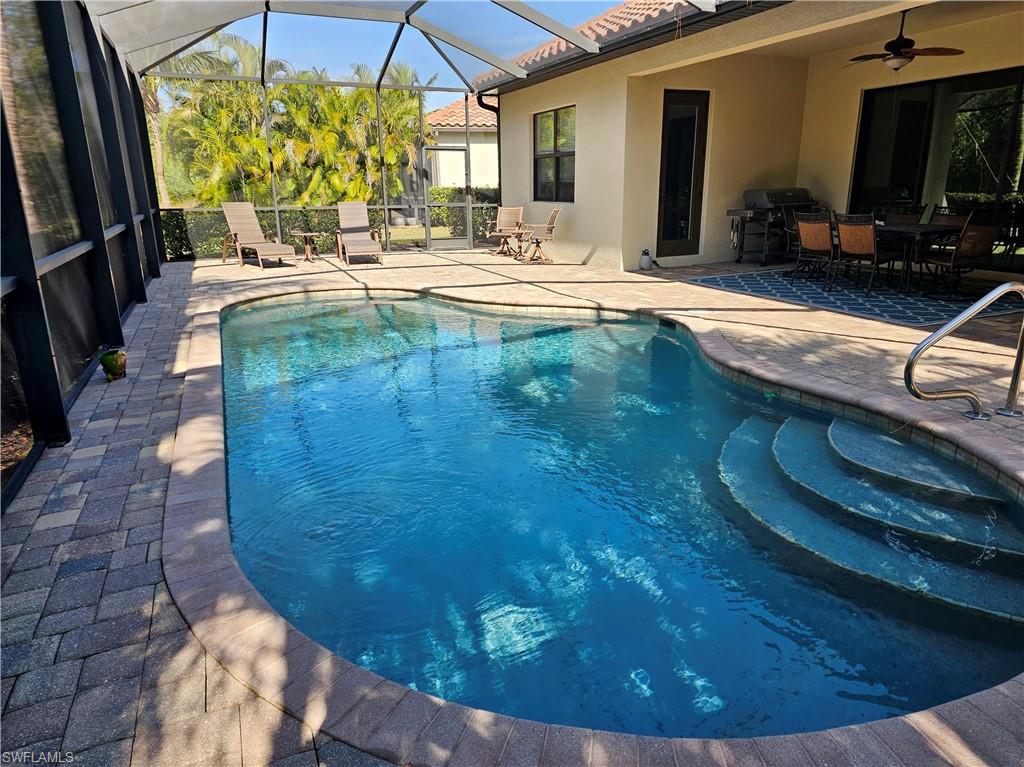 View of pool with ceiling fan, a fenced in pool, glass enclosure, outdoor dining area, and a patio area