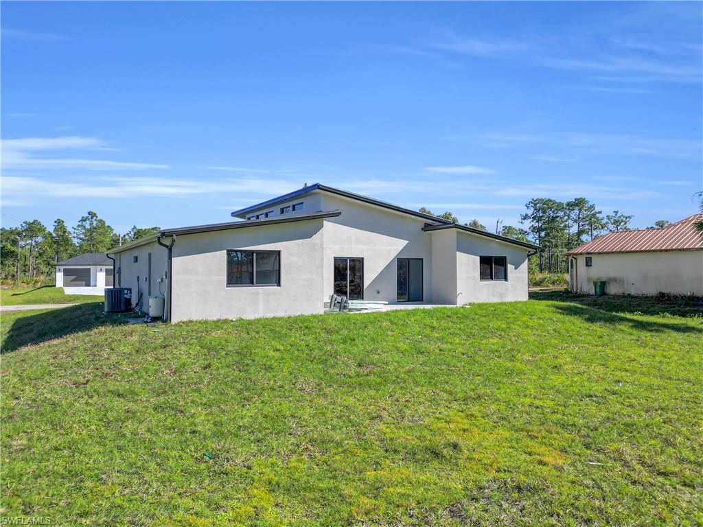 Back of property featuring a yard and stucco siding
