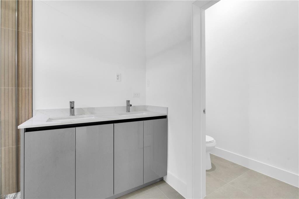 Bathroom with double vanity and light tile patterned flooring