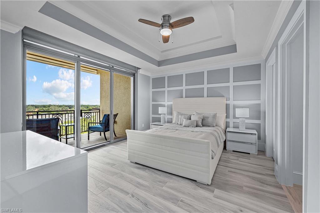 Bedroom featuring light hardwood / wood-style flooring, a raised ceiling, access to outside, ceiling fan, and ornamental molding