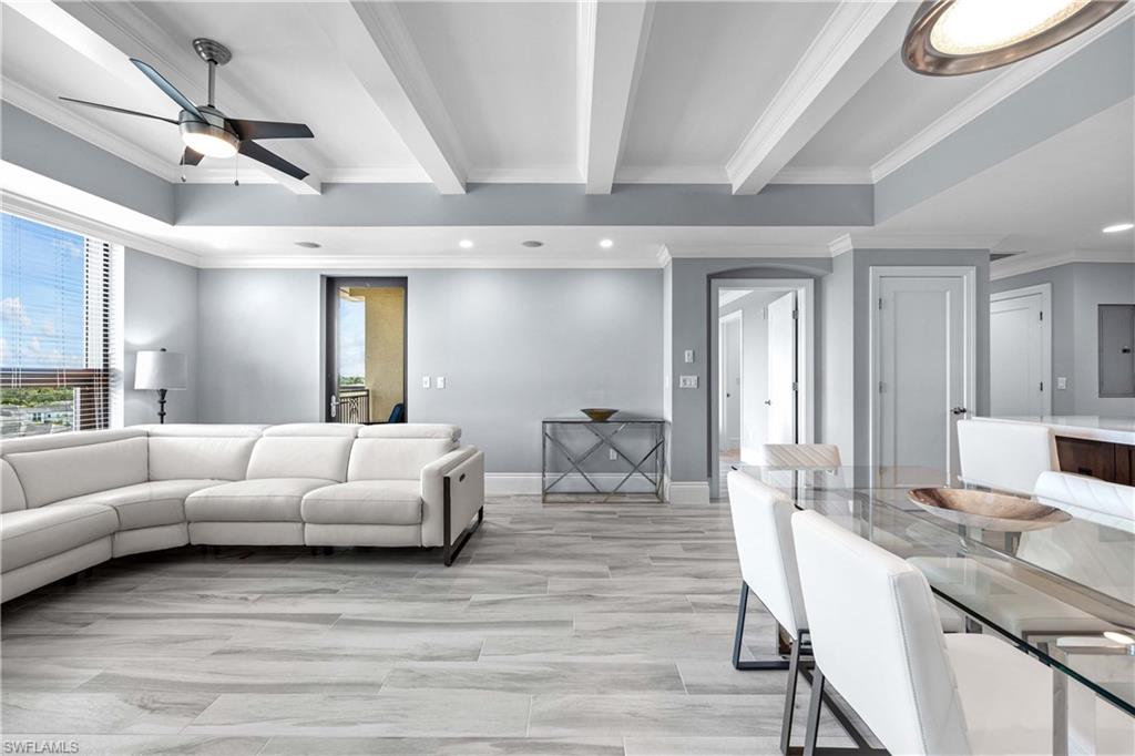 Living room with crown molding, ceiling fan, light hardwood / wood-style flooring, and beam ceiling
