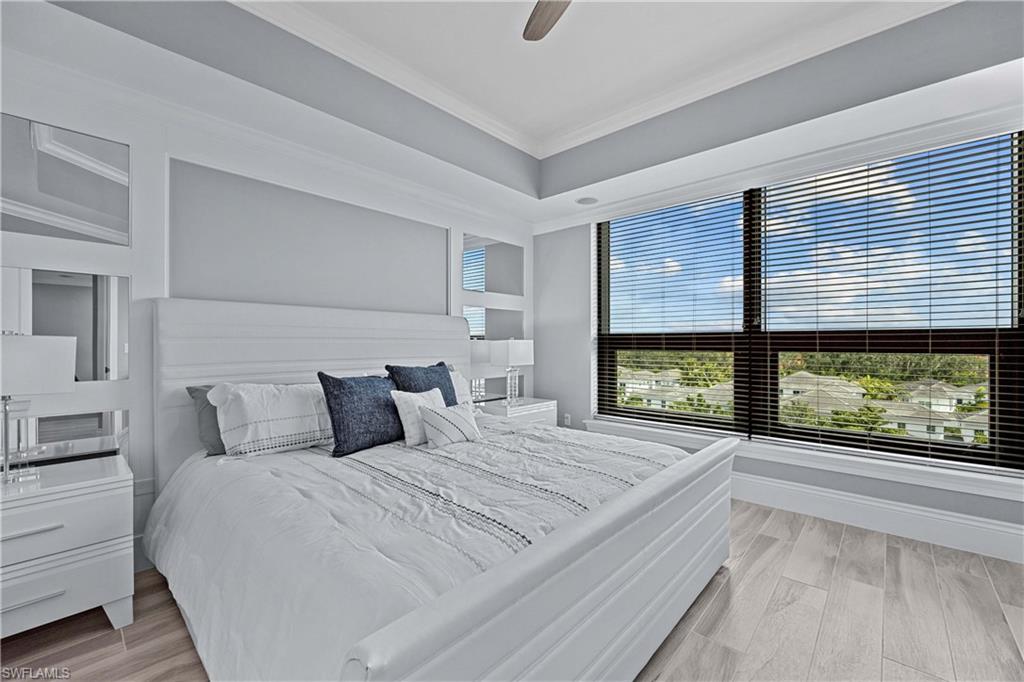 Bedroom featuring light wood-type flooring, ceiling fan, and ornamental molding