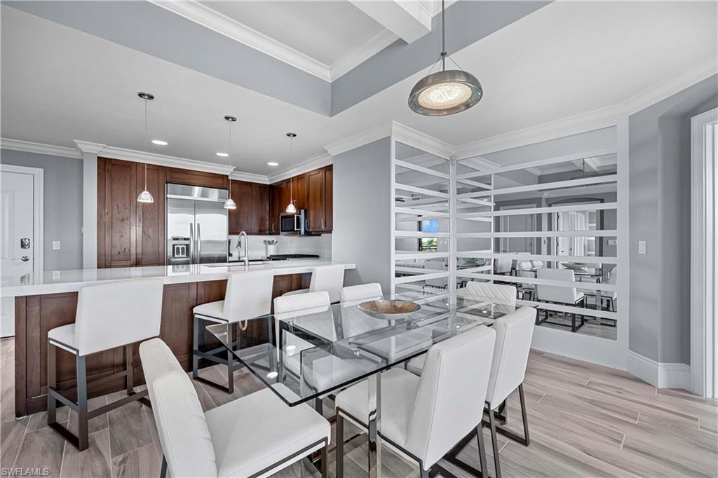 Dining space with ornamental molding, sink, and light wood-type flooring