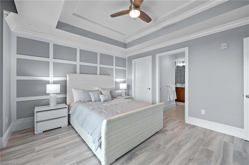 Bedroom with ensuite bath, crown molding, light hardwood / wood-style flooring, and ceiling fan