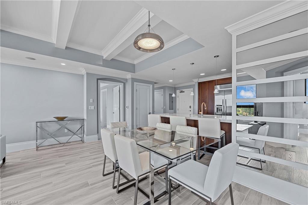 Dining space with light wood-type flooring, sink, and ornamental molding