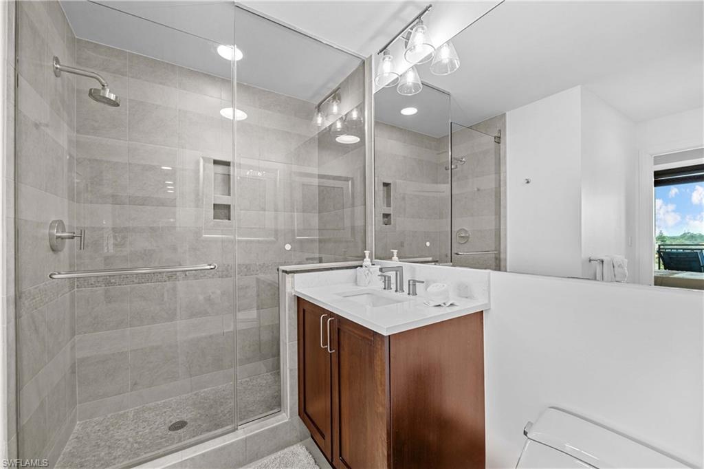 Bathroom featuring a shower with door and vanity