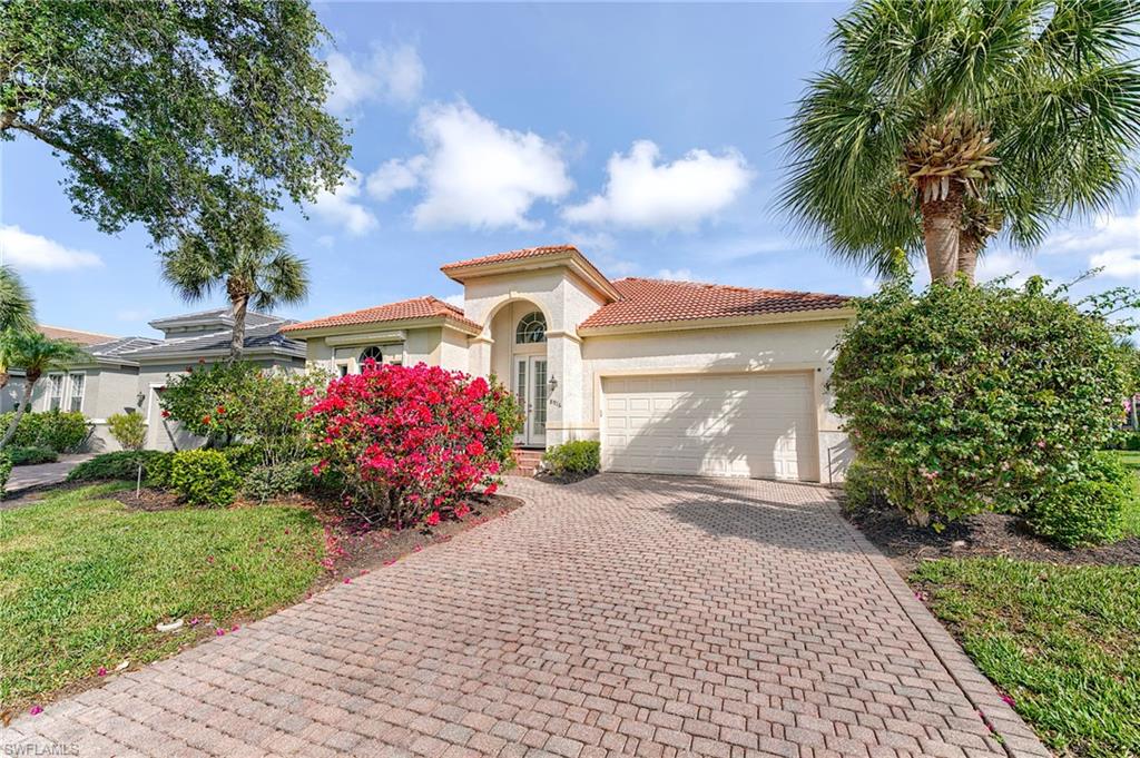 Street view of paver stone driveway and flowering plants