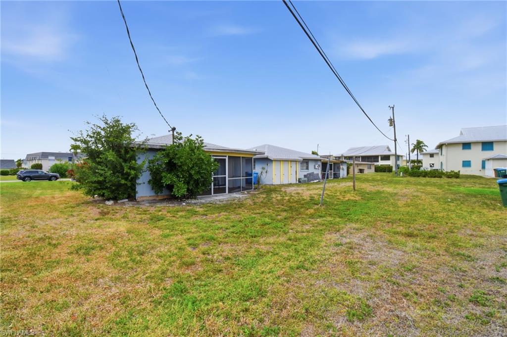 Expansive grassy yard area with partial landscaping