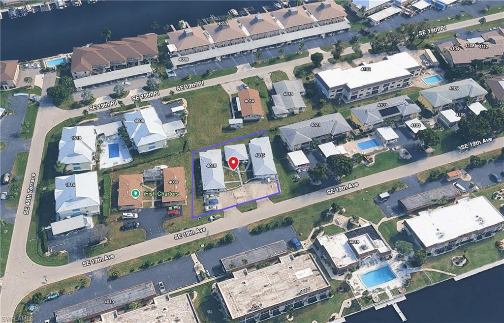 Aerial perspective highlighting a property with two residential structures and an expansive parking area