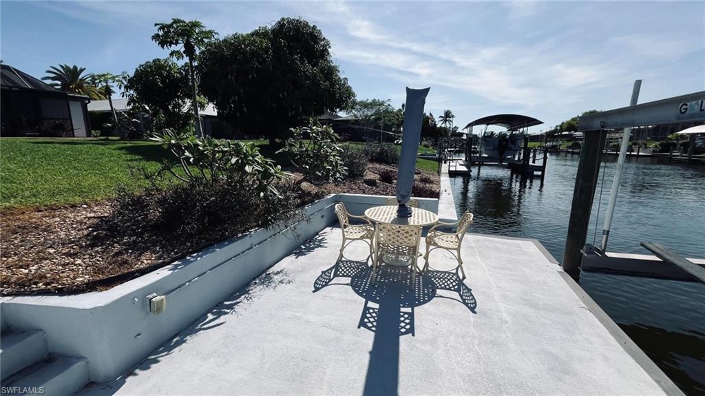 Waterfront property featuring a concrete dock, direct canal access, and a boat lift structure