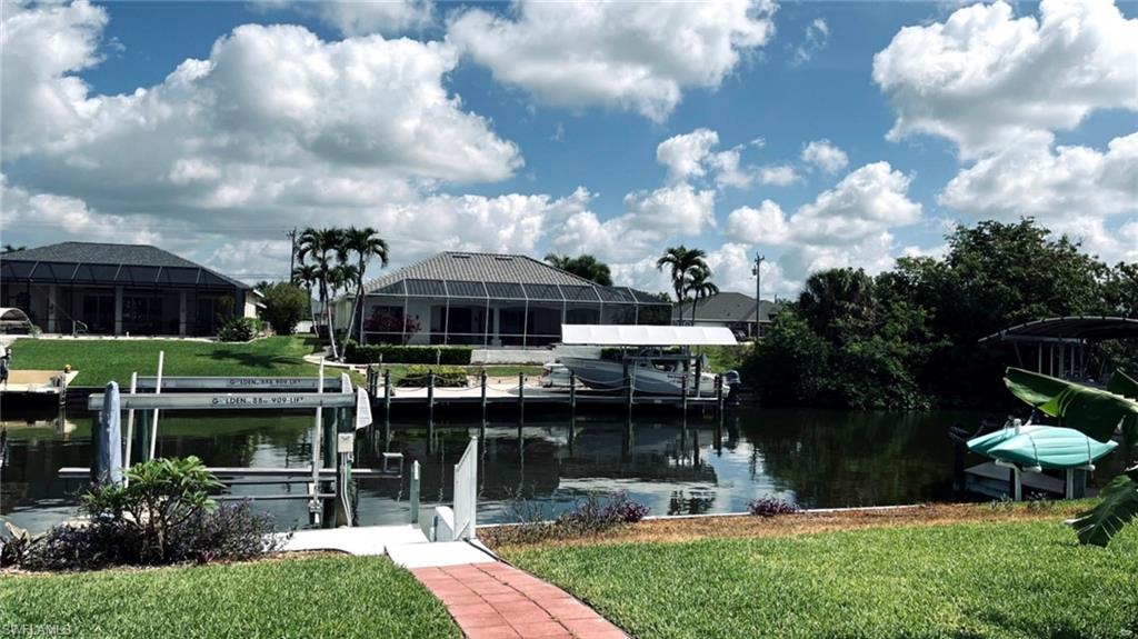 Waterfront property featuring a private boat lift, concrete dock, and direct canal access