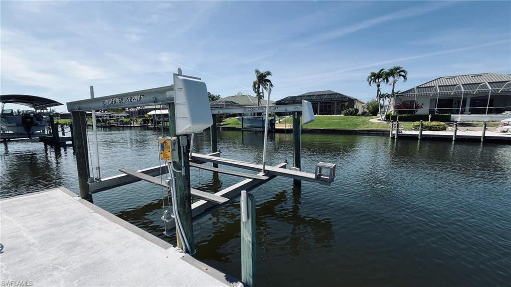 Private dock featuring a concrete platform, pilings, and a boat lift