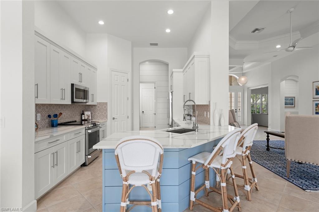 Renovated Kitchen with Quartz countertops, white kitchen cabinets and stainless steel appliances.